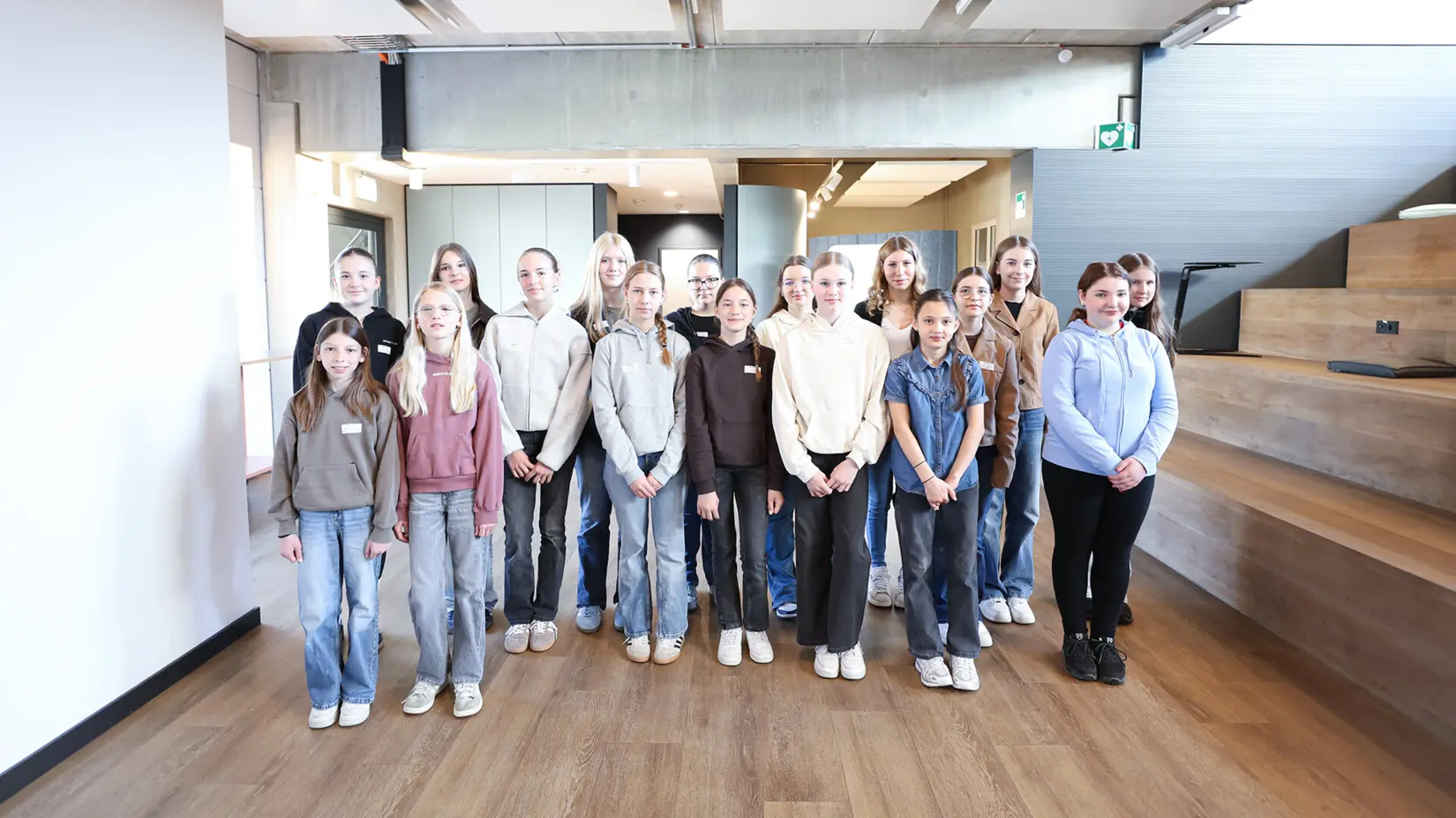 Grupo de jovens mulheres e meninas em um moderno espaço de escritório para o evento NETZSCH Girls' Day, que promove a diversidade e a inovação.